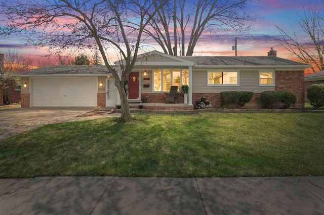 view of front of property featuring an attached garage, a front lawn, driveway, and brick siding
