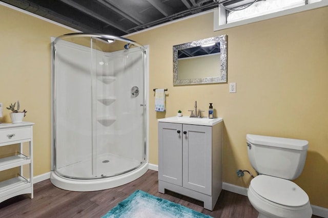 full bath with a shower stall, wood finished floors, toilet, vanity, and baseboards