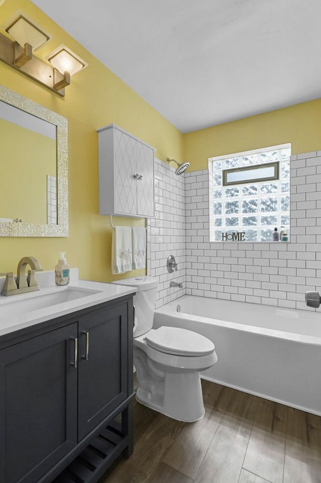 bathroom with vanity, toilet, shower / washtub combination, and wood finished floors
