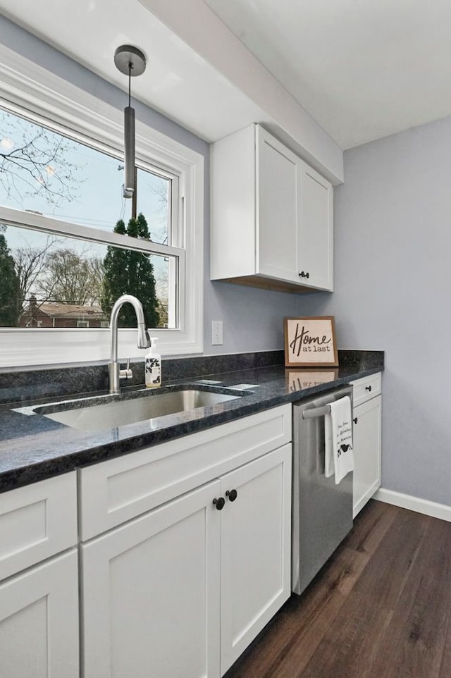 kitchen with dark stone counters, stainless steel dishwasher, a sink, white cabinets, and dark wood-style flooring