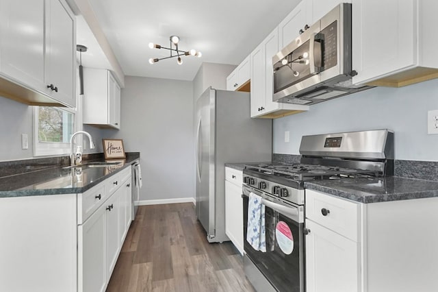 kitchen featuring white cabinets, dark wood-style floors, a sink, and appliances with stainless steel finishes