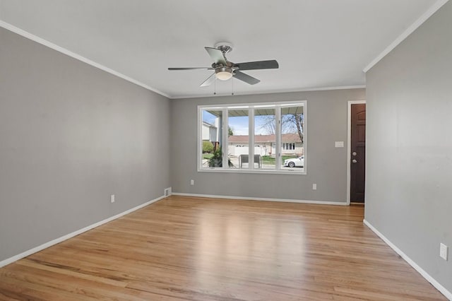 unfurnished room with a ceiling fan, baseboards, light wood-style flooring, and crown molding