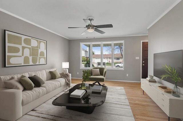 living room with ceiling fan, baseboards, ornamental molding, and light wood finished floors