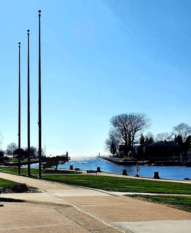view of property's community with a water view and a yard