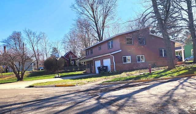 view of front of home with brick siding, driveway, and a garage