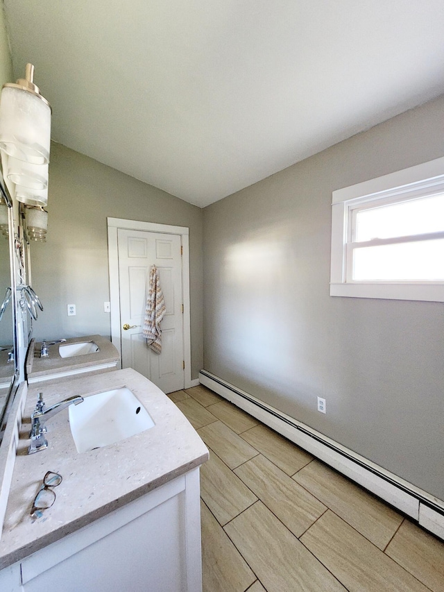 bathroom featuring a baseboard radiator, vanity, and vaulted ceiling