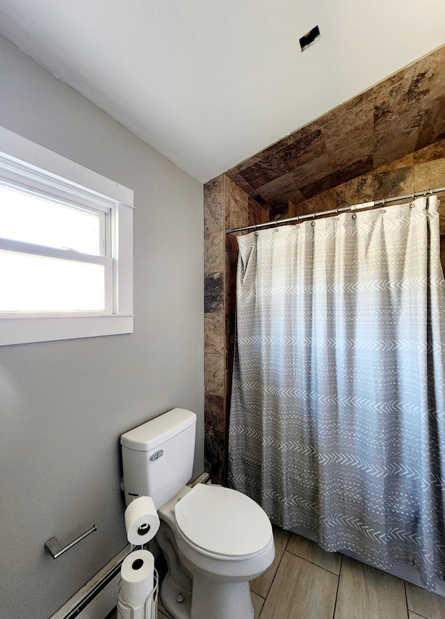 full bath with toilet, a baseboard radiator, and a shower with shower curtain