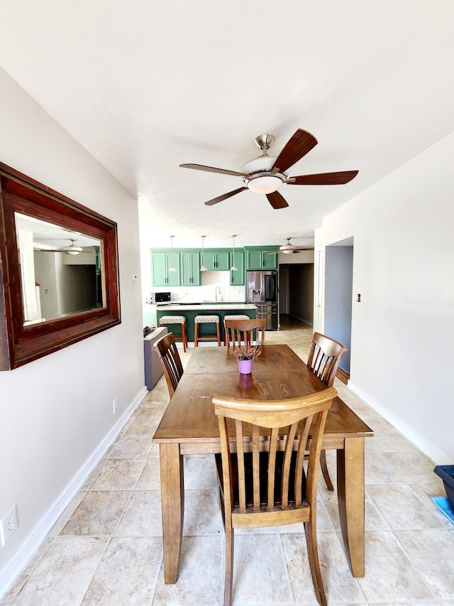 dining area featuring ceiling fan and baseboards