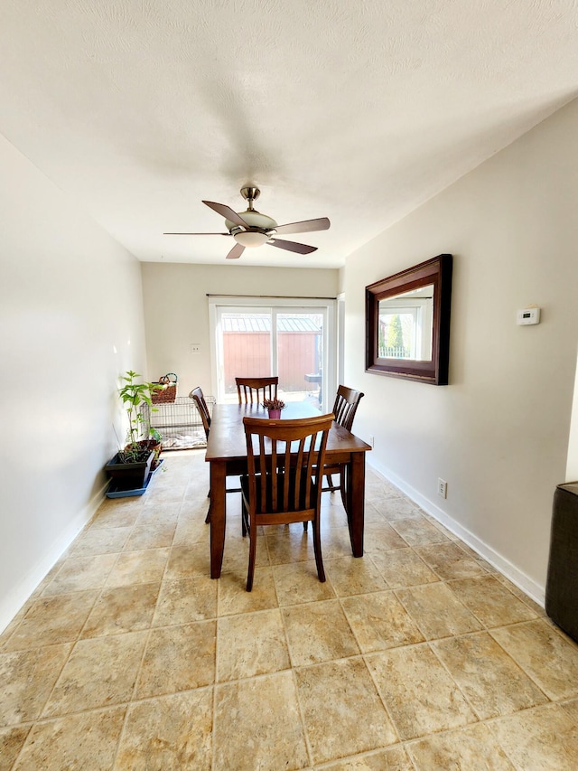 dining space featuring ceiling fan, baseboards, and a textured ceiling
