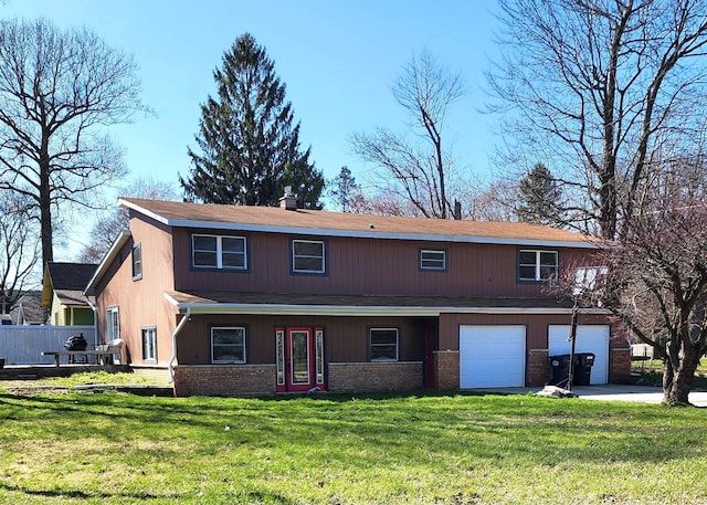 view of front facade featuring a garage, a front yard, driveway, and brick siding