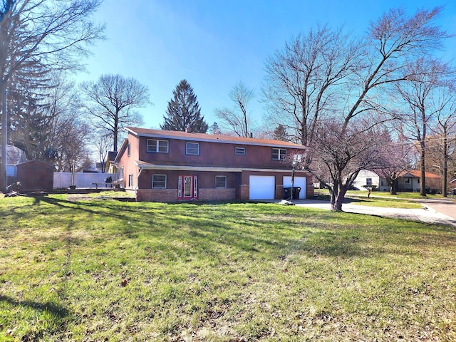 rear view of house with concrete driveway, a yard, fence, and an attached garage