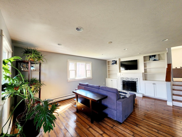 living area with a fireplace, dark wood-type flooring, a textured ceiling, recessed lighting, and baseboard heating