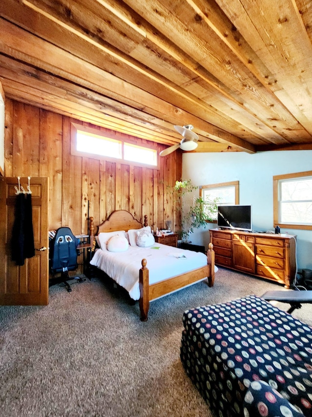 carpeted bedroom featuring wooden walls and multiple windows
