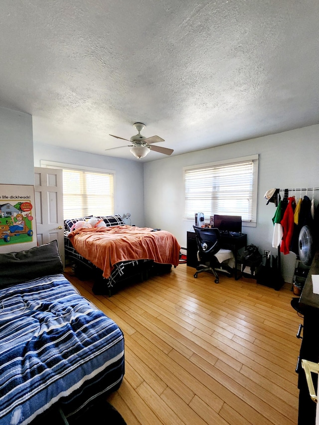 bedroom featuring a textured ceiling, wood finished floors, and a ceiling fan