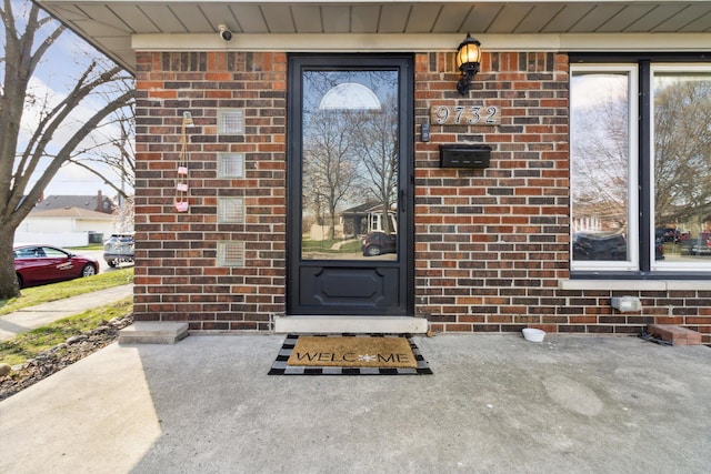 doorway to property with brick siding