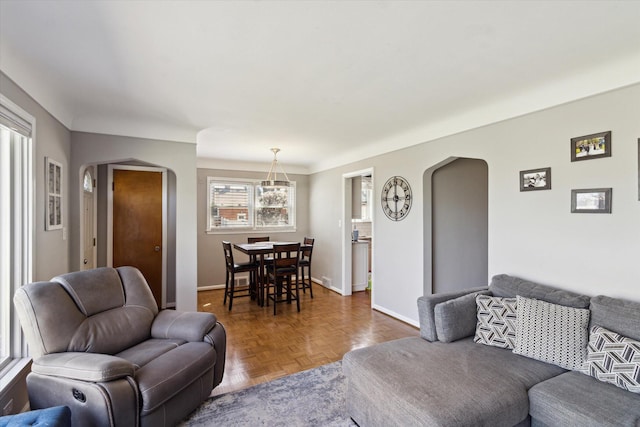 living area with arched walkways and baseboards