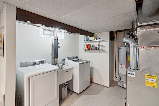 clothes washing area featuring water heater, laundry area, washing machine and clothes dryer, and light floors