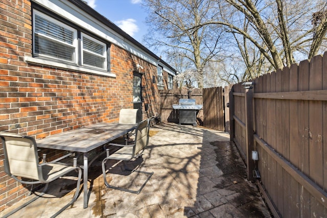 view of patio with a grill, outdoor dining space, and fence