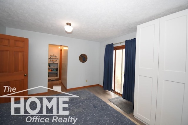 interior space featuring baseboards, wood finished floors, and a textured ceiling