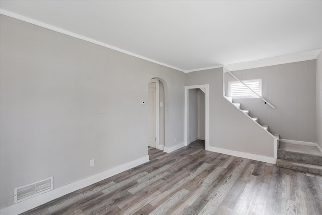23737 Couzens Ave, Hazel Park, MI 48030 - unfurnished living room with arched walkways, baseboards, visible vents, wood finished floors, and stairs