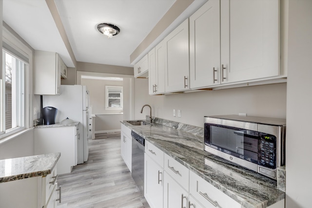 23737 Couzens Ave, Hazel Park, MI 48030 - kitchen with light stone counters, light wood-type flooring, stainless steel appliances, and a sink