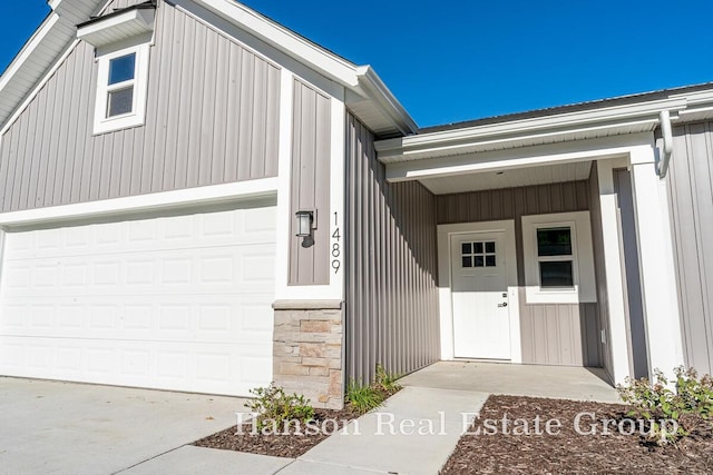 doorway to property featuring driveway and stone siding