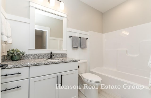bathroom featuring toilet, shower / bathing tub combination, and vanity