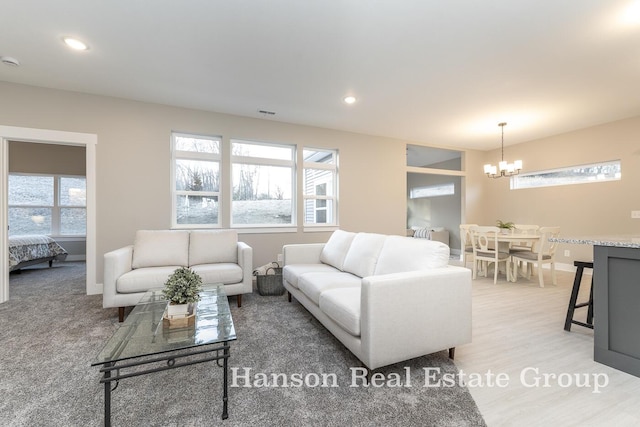 living area with light wood-style flooring, an inviting chandelier, baseboards, and recessed lighting