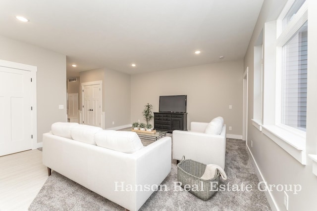 living area featuring baseboards, visible vents, and recessed lighting