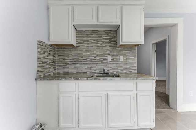 1409 Charter St, Lincoln Park, MI 48146 - kitchen featuring white cabinets, dark stone countertops, a sink, and decorative backsplash