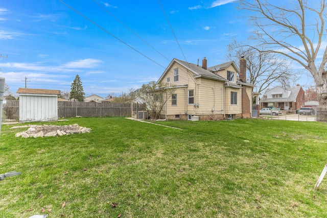 1409 Charter St, Lincoln Park, MI 48146 - exterior space with a shed, a fenced backyard, an outdoor structure, a lawn, and a chimney
