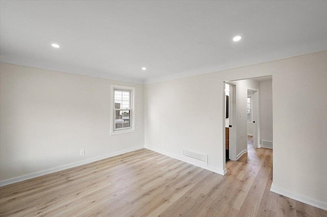 empty room with visible vents, baseboards, and light wood-style floors