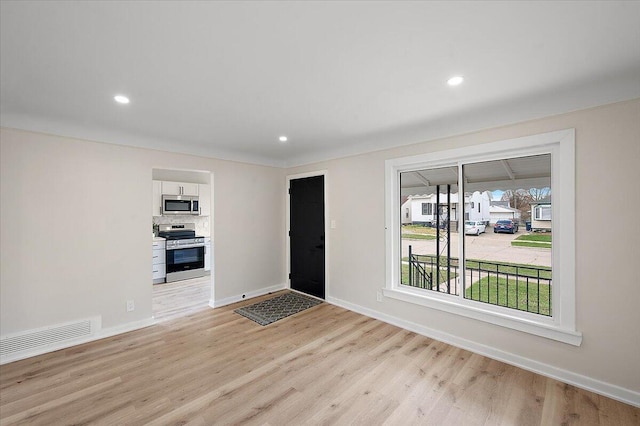 foyer entrance with recessed lighting, light wood-style floors, visible vents, and baseboards