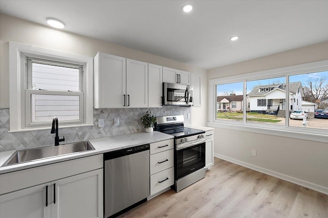 kitchen with stainless steel appliances, tasteful backsplash, baseboards, and a sink