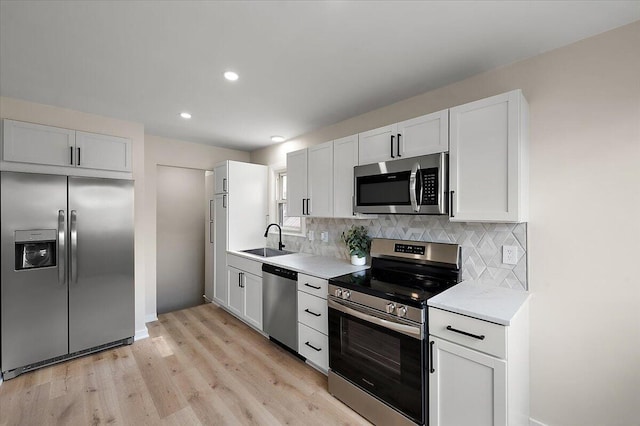 kitchen with a sink, backsplash, light countertops, and stainless steel appliances