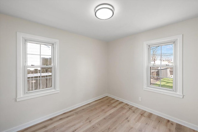 unfurnished room with baseboards and light wood-type flooring