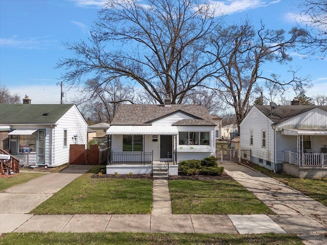 bungalow-style home with concrete driveway, fence, a gate, and covered porch