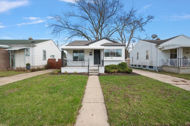 bungalow-style home with roof with shingles, a front yard, and a porch