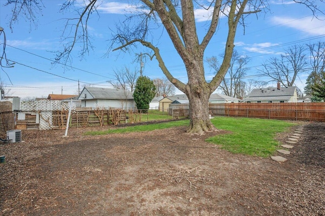 view of yard with central AC unit and fence