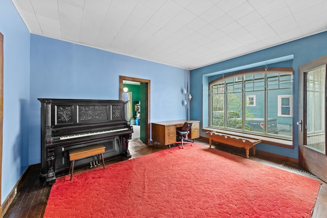 living area with baseboards and dark wood-type flooring