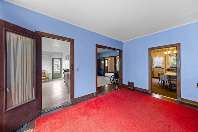 spare room featuring baseboards, ornamental molding, wood finished floors, and visible vents
