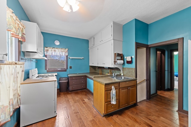 kitchen with white cabinets, washer / clothes dryer, a sink, and light wood-type flooring