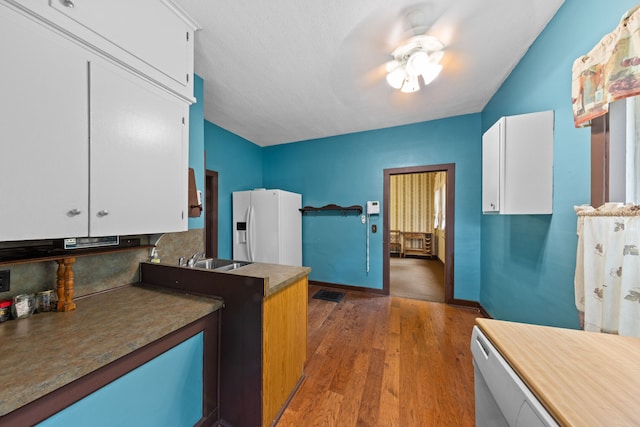 kitchen with white cabinets, a ceiling fan, wood finished floors, and white fridge with ice dispenser