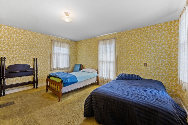 carpeted bedroom with wallpapered walls