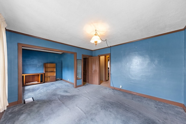 unfurnished bedroom featuring baseboards, carpet, and crown molding