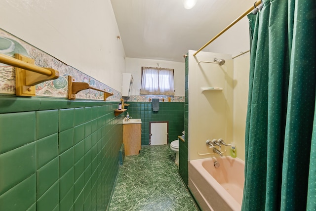 bathroom with a sink, toilet, tile walls, wainscoting, and shower / bathtub combination with curtain