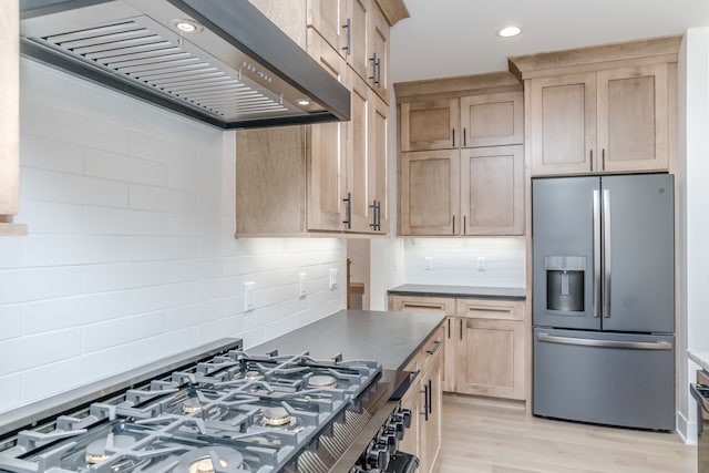 kitchen with light wood finished floors, range hood, backsplash, stovetop, and stainless steel refrigerator with ice dispenser