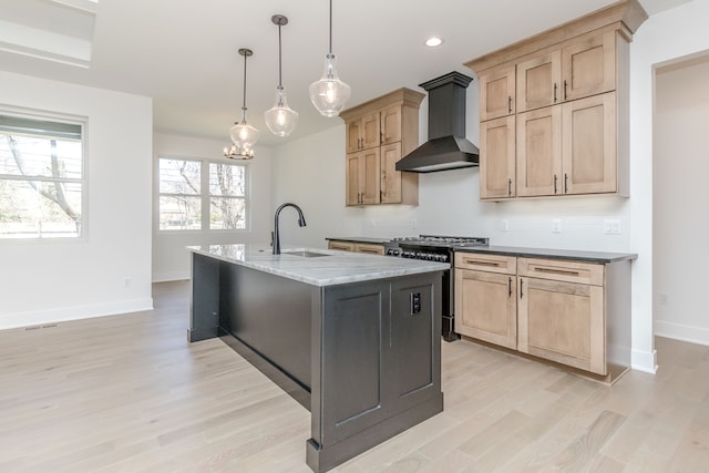 kitchen featuring wall chimney exhaust hood, light wood-style flooring, a sink, baseboards, and gas range
