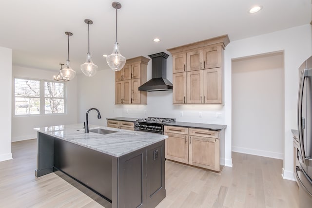 kitchen featuring wall chimney range hood, range with gas stovetop, a sink, decorative backsplash, and baseboards