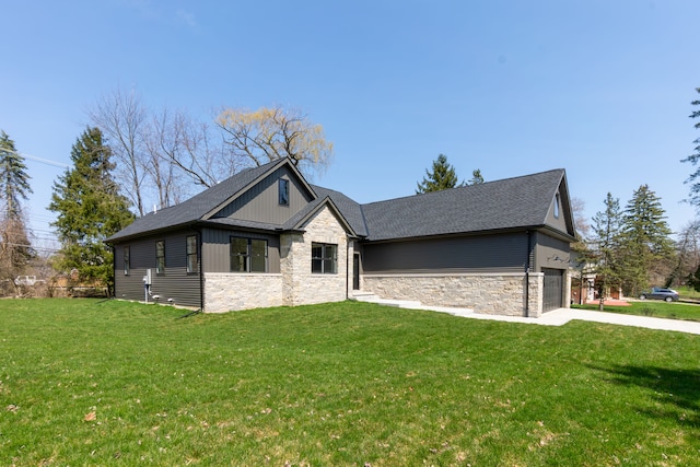 view of front of house featuring stone siding, board and batten siding, a front yard, and a garage
